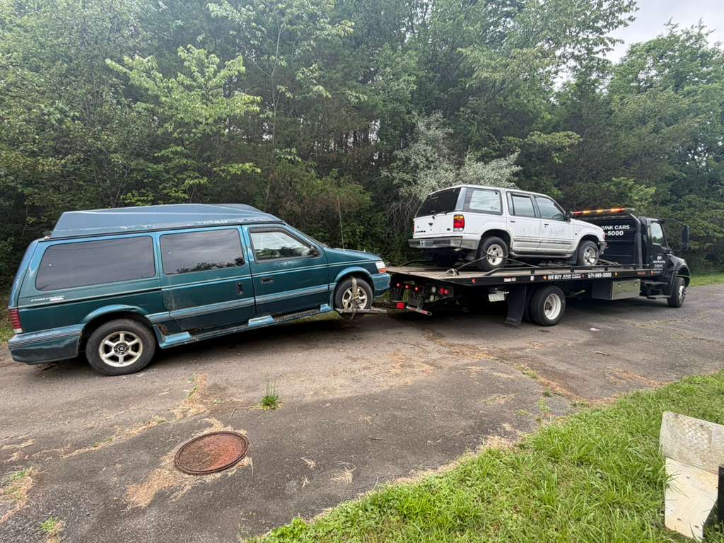 Older van and SUV loaded during a multi-vehicle junk car pickup in Arlington, VA